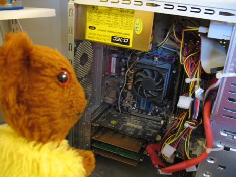 Yellow Teddy watching the computer being repaired