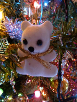 White teddy decoration on Christmas tree