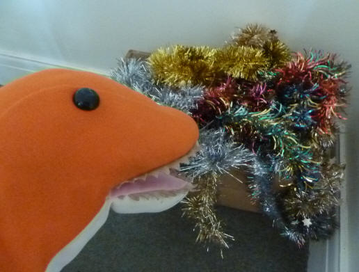 Dino playing nestts with tinsel