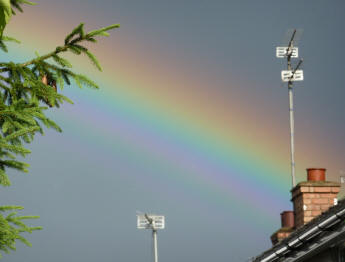 Triple rainbow over houses