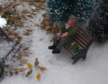 Christmas model villages - man feeding birds